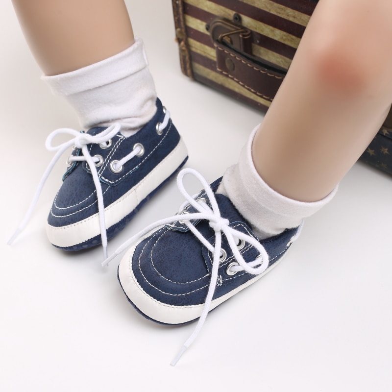Jambes de bébé portant des chaussettes blanches et des mocassins bleus style bateau