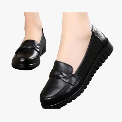 on voit une paire de mocassins noirs portés par une femme on ne voit que ses pieds