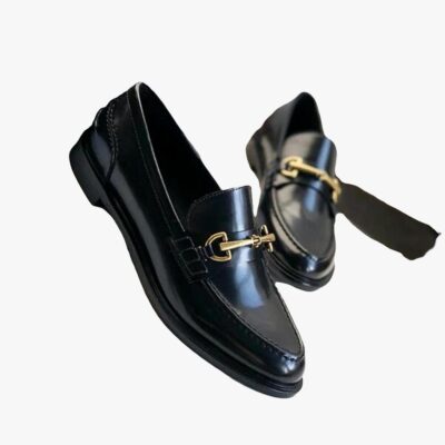 on voit sur un fond blanc une paire de mocassins noirs en cuir véritable à talon carré pour femme