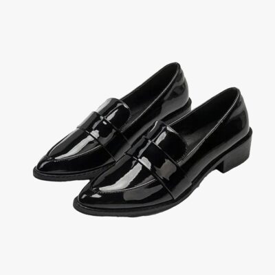on voit sur un fond gris clair une paire de mocassins noirs vernis à bout pointu pour femme