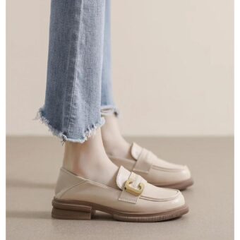 on voit les pieds d'une femme qui porte un jean, elle porte des mocassins beiges souples en cuir synthétique