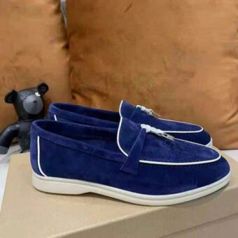 Paire de mocassins bleus en suédine posés sur une boite à chaussures