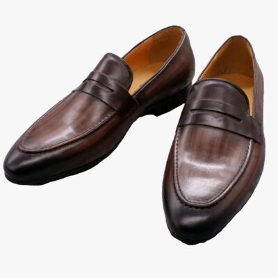 on voit sur un fond gris clair une paire de mocassins marron foncé pour homme en cuir véritable