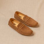 mocassin classico marron posé au sol sur un fond beige