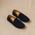 mocassin classico bleu posé au sol sur un fond beige
