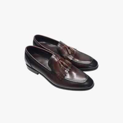 Mocassins pour homme en cuir brillant marron avec une finition élégante. Ces chaussures sont ornées de glands décoratifs et de franges perforées sur le dessus, offrant un style sophistiqué et intemporel, parfait pour les occasions formelles ou professionnelles.