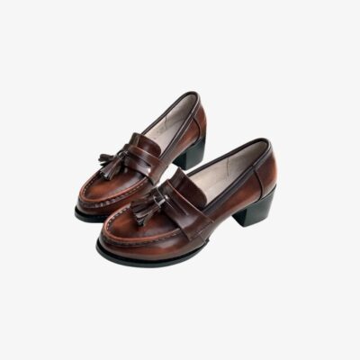 Mocassins pour femme en cuir marron, ornés de glands décoratifs sur le dessus pour un style classique et élégant. Ces chaussures sont dotées de talons carrés noirs, offrant à la fois confort et stabilité, idéales pour une allure sophistiquée au quotidien.