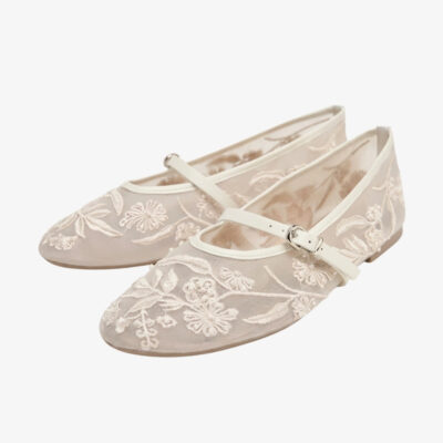 Mocassin ballerine de couleur blanche avec des broderies florales et une bride, sur fond gris