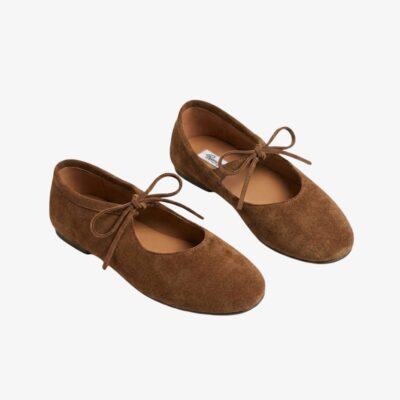 Mocassin ballerine en daim marron cognac, avec un noeud sur le devant, sur fond gris