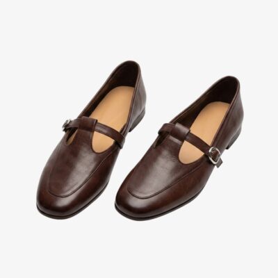 Mocassin ballerine style vintage avec une bride en forme de T, de couleur marron, sur fond gris