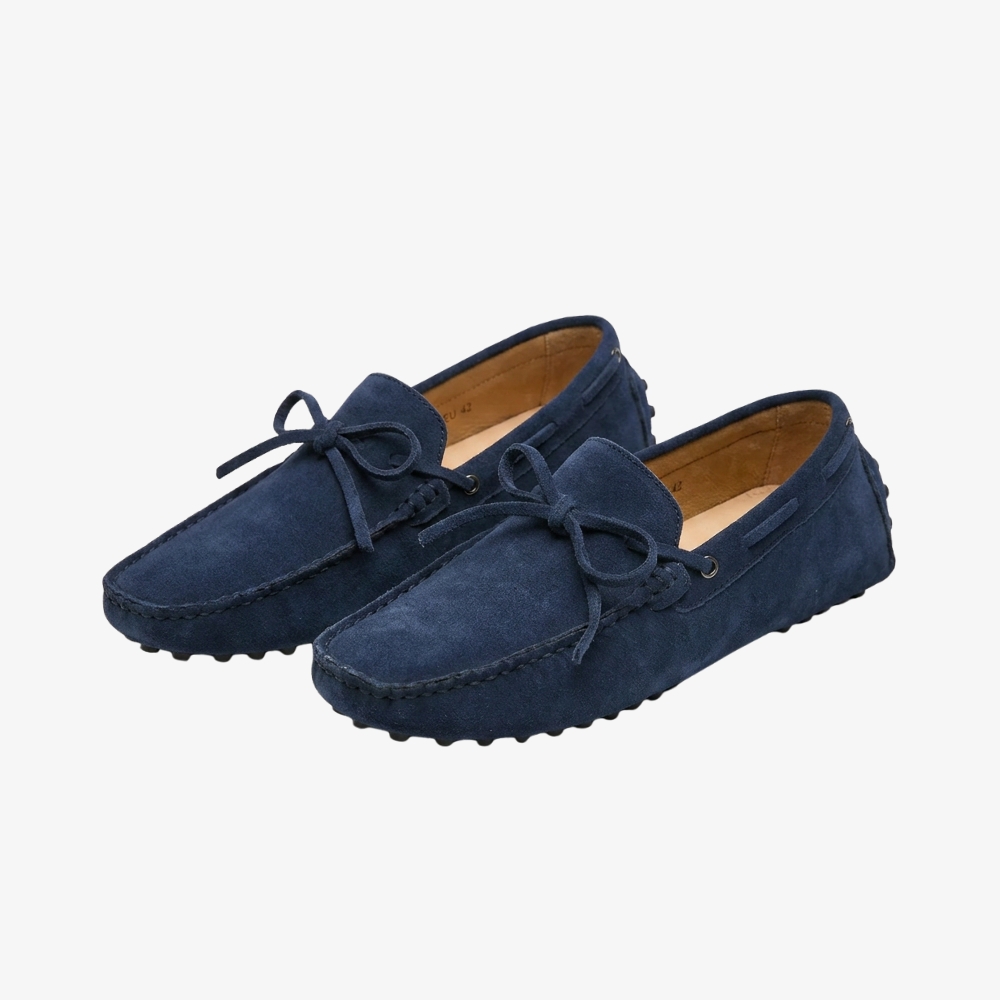 Mocassin pour homme élégant en daim bleu foncé avec un noeud sur le devant, style old money, sur fond gris